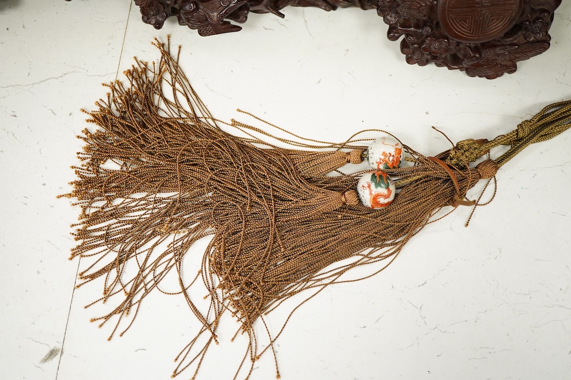 A Chinese carved hardwood Ruyi sceptre, with two porcelain ‘dragon’ beads, 50cm in length